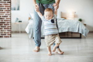 bébé fait se premiers pas avec papa.